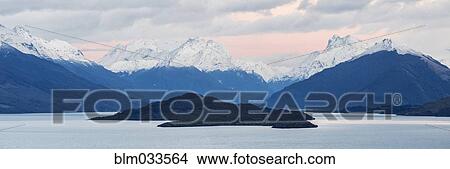Snowcapped mountains and island near remote lake, Queenstown, Central Otago, New Zealand View Large Photo Image Picture - Snowcapped mountains and island near remote lake, Queenstown, Central Otago, New Zealand. Fotosearch
