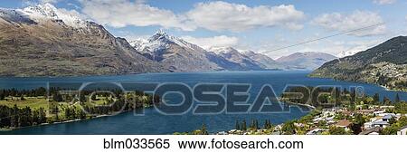 Stock Photography - Snowcapped mountains and town near lake, Queenstown, Central Otago, New Zealand. Fotosearch