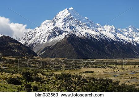 Snowcapped mountains over remote field, Mount Cook Village, Mckenzie Country, New Zealand View Large Photo Image Stock Photo - Snowcapped mountains over remote field, Mount Cook Village, Mckenzie Country, New Zealand. Fotosearch