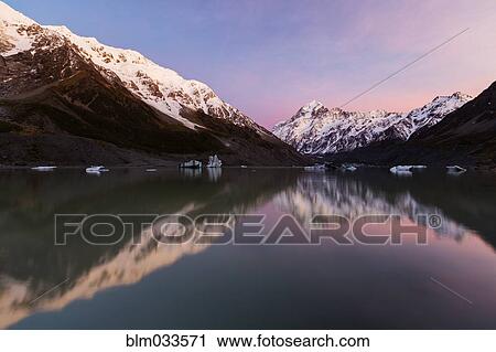 Snowcapped mountains reflecting in still lake, Mount Cook Village, Mckenzie Country, New Zealand View Large Photo Image Stock Image - Snowcapped mountains reflecting in still lake, Mount Cook Village, Mckenzie Country, New Zealand. Fotosearch