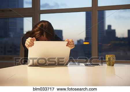 Stressed Caucasian businesswoman holding laptop in office View Large Photo Image Stock Photo - Stressed Caucasian businesswoman holding laptop in office. Fotosearch