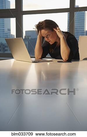 Stressed Caucasian businesswoman using laptop in office View Large Photo Image Stock Photo - Stressed Caucasian businesswoman using laptop in office. Fotosearch