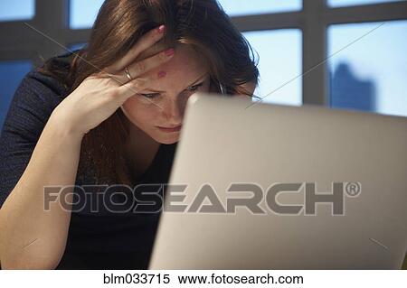 Stock Photography - Stressed Caucasian businesswoman using laptop in office . Fotosearch