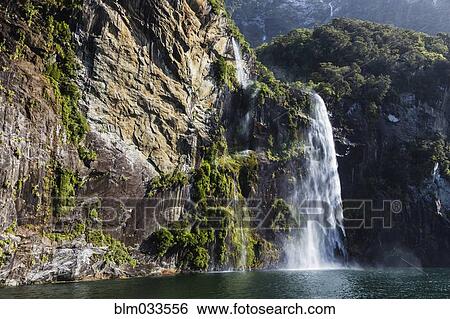 Waterfall over sheer cliffs to remote river, Te Anau, Southland, New Zealand View Large Photo Image Stock Photograph - Waterfall over sheer cliffs to remote river, Te Anau, Southland, New Zealand. Fotosearch