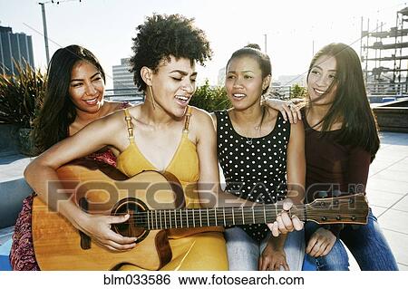 Stock Photograph - Women playing music and singing on urban rooftop. Fotosearch