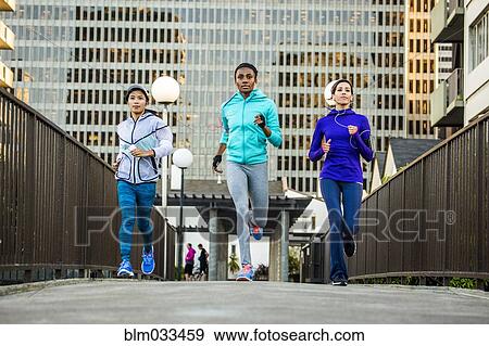 Stock Photo - Women running in city. Fotosearch