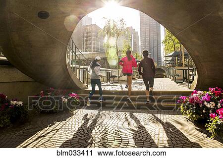 Stock Image - Women running in urban park. Fotosearch
