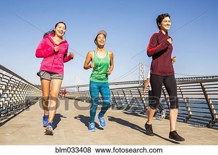 Stock Photo - Women running on urban footbridge, San Francisco, California, United States. Fotosearch
