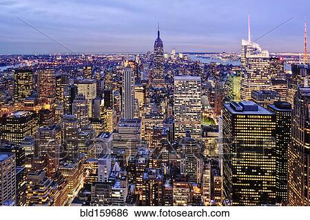 Stock Photograph - Aerial view of highrise buildings in cityscape at twilight. Fotosearch