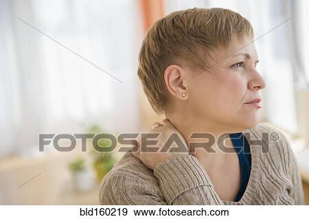Stock Photo - Anxious Caucasian woman rubbing her neck. Fotosearch