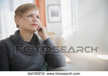 Anxious Caucasian woman sitting on sofa View Large Photo Image Stock Image - Anxious Caucasian woman sitting on sofa. Fotosearch