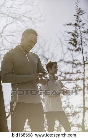 Stock Photo - Athletes checking sports watches. Fotosearch