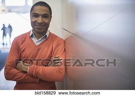 Stock Photo - Black businessman smiling near wall. Fotosearch