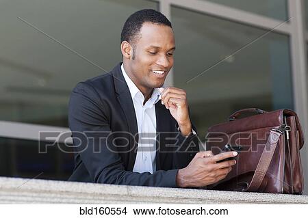 Black businessman using cell phone View Large Photo Image Picture - Black businessman using cell phone. Fotosearch