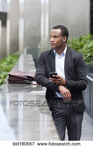 Black businessman using cell phone outdoors View Large Photo Image Stock Photo - Black businessman using cell phone outdoors. Fotosearch