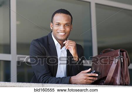 Stock Photography - Black businessman using cell phone. Fotosearch