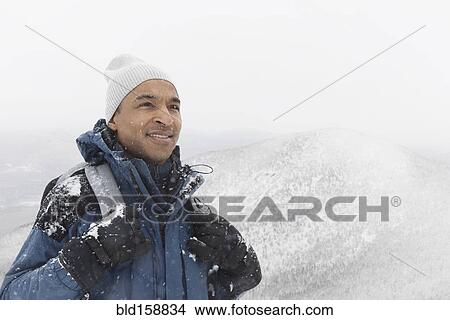 Picture - Black man hiking in snow. Fotosearch