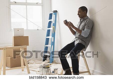 Black man sitting in room under renovation View Large Photo Image Stock Image - Black man sitting in room under renovation. Fotosearch