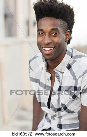 Stock Image - Black man smiling outdoors. Fotosearch
