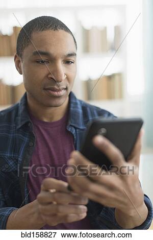 Stock Photo - Black man using digital tablet. Fotosearch