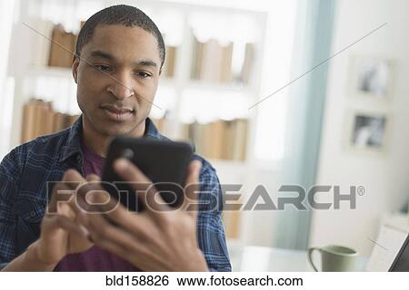 Stock Photograph - Black man using digital tablet. Fotosearch