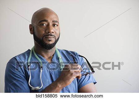 Stock Photography - Black nurse holding eyeglasses. Fotosearch