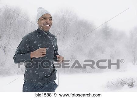 Stock Photo - Black runner jogging in snow. Fotosearch