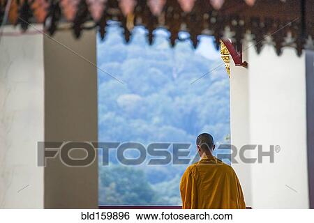 Stock Photograph - Buddhist monk admiring scenic view from temple. Fotosearch