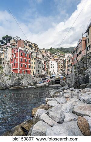 Stock Photo - Buildings and rocky coastline near harbor, Manarola, La Spezia, Italy. Fotosearch