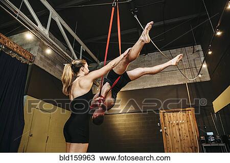 Stock Image - Caucasian acrobats training on ropes in studio. Fotosearch