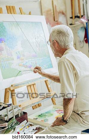 Picture - Caucasian artist painting in studio. Fotosearch