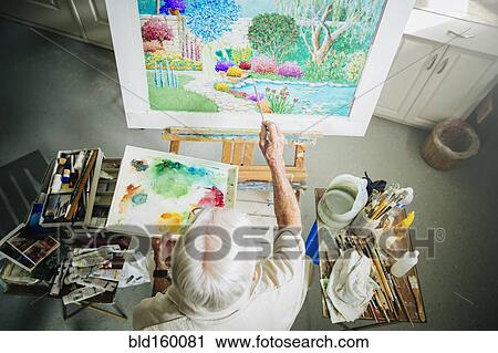 Stock Image - Caucasian artist painting in studio. Fotosearch