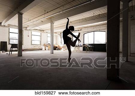 Stock Photo - Caucasian ballet dancer performing in loft room. Fotosearch