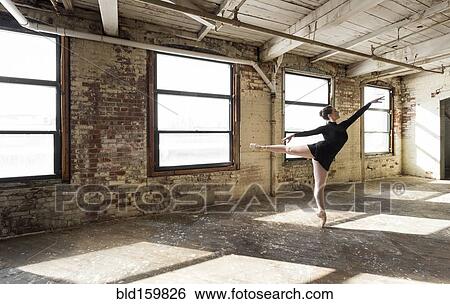 Stock Photograph - Caucasian ballet dancer performing in sunny loft room. Fotosearch