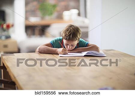 Stock Photograph - Caucasian boy drawing at table. Fotosearch