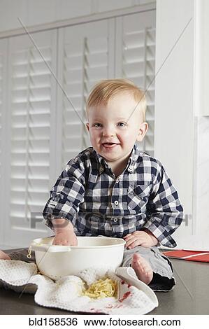 Caucasian boy playing with food in kitchen View Large Photo Image Stock Photograph - Caucasian boy playing with food in kitchen. Fotosearch