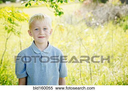 Stock Photography - Caucasian boy smiling in tall grass. Fotosearch