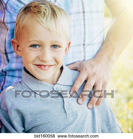 Stock Photo - Caucasian boy smiling with father outdoors. Fotosearch