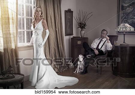 Picture - Caucasian bride and groom in study with dogs. Fotosearch