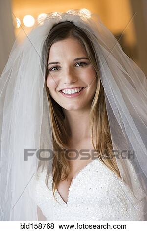 Caucasian bride smiling in wedding gown and veil View Large Photo Image Stock Photo - Caucasian bride smiling in wedding gown and veil. Fotosearch