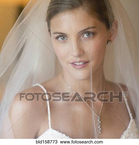Stock Image - Caucasian bride wearing wedding gown and veil. Fotosearch