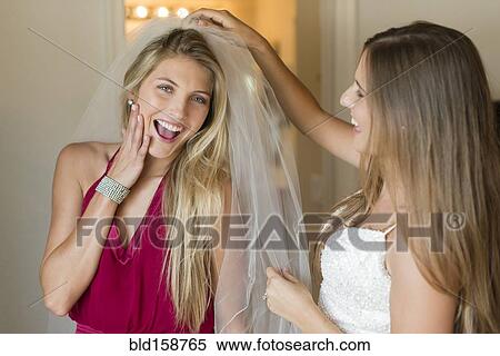 Caucasian bridesmaid wearing veil of bride View Large Photo Image Stock Photography - Caucasian bridesmaid wearing veil of bride. Fotosearch