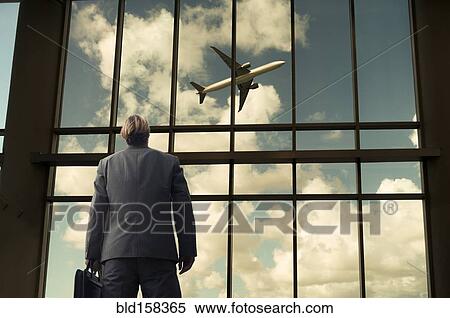 Caucasian businessman admiring airplane from airport windows View Large Photo Image Stock Photography - Caucasian businessman admiring airplane from airport windows. Fotosearch