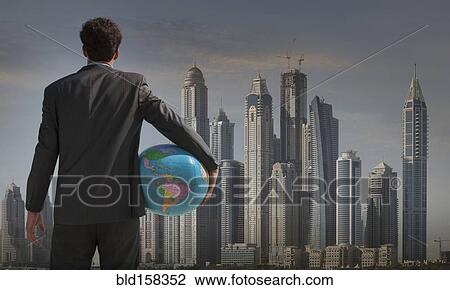 Caucasian businessman holding globe near Qatar cityscape, Qatar View Large Photo Image Stock Image - Caucasian businessman holding globe near Qatar cityscape, Qatar. Fotosearch