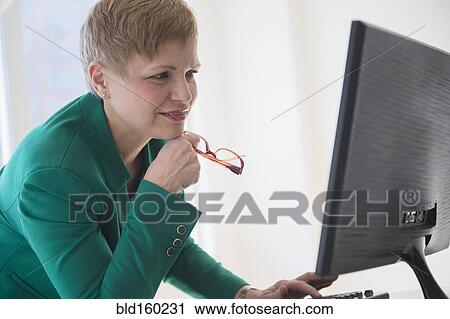 Stock Image - Caucasian businesswoman working at computer. Fotosearch