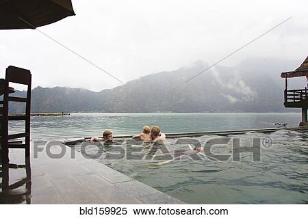 Stock Photography - Caucasian children admiring scenic view from swimming pool. Fotosearch