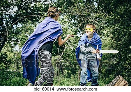 Picture - Caucasian children in costumes playing with swords. Fotosearch