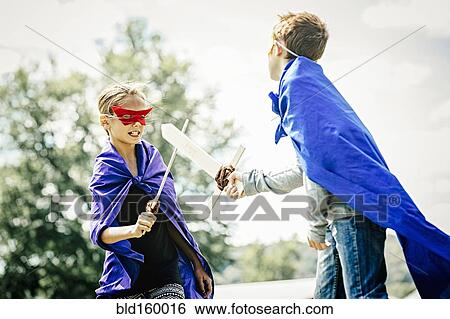 Stock Photograph - Caucasian children in costumes playing with swords. Fotosearch