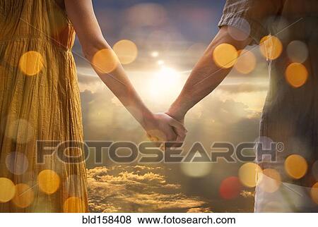 Caucasian couple holding hands in dramatic sunset sky View Large Photo Image Stock Photo - Caucasian couple holding hands in dramatic sunset sky. Fotosearch