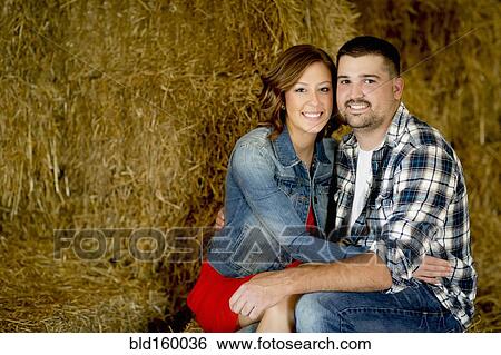 Caucasian couple hugging in haystacks View Large Photo Image Stock Photograph - Caucasian couple hugging in haystacks. Fotosearch